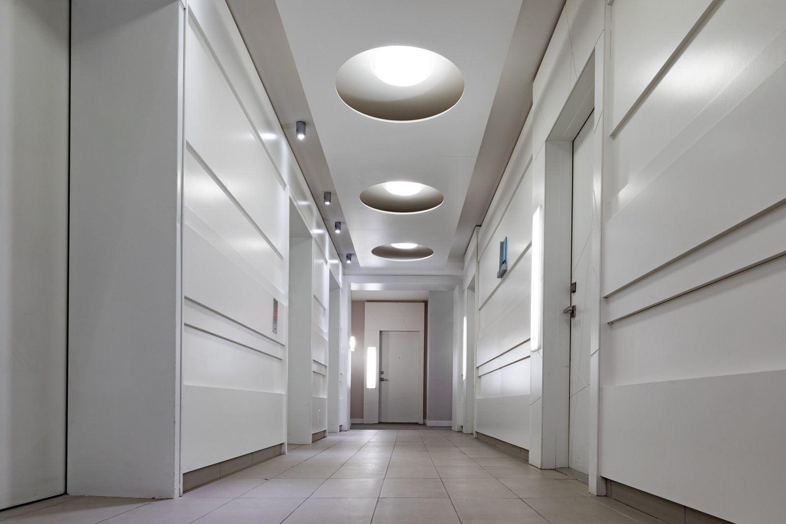 A bright communal corridor with recessed ceiling lighting